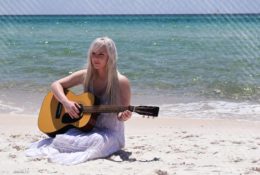 Musician Playing Guitar by the Beach