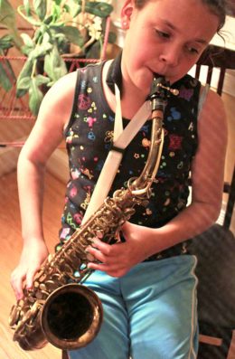 girl playing vintage king zephyr saxophone